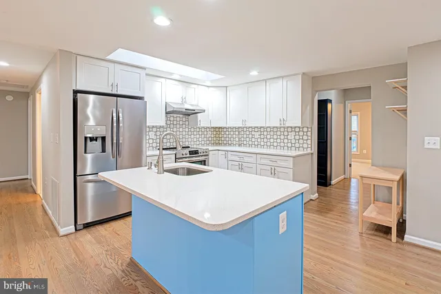 a kitchen with stainless steel appliances a refrigerator and wooden floor