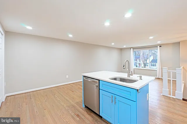 a kitchen with a sink cabinets and wooden floor