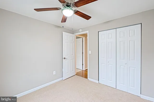 an empty room with closet and a chandelier fan
