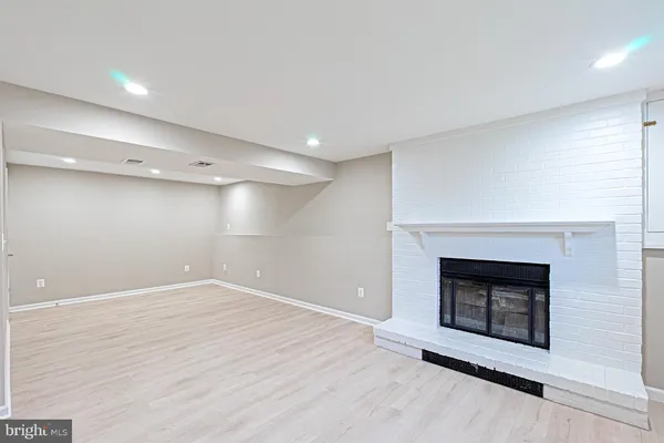 an empty room with wooden floor and fireplace