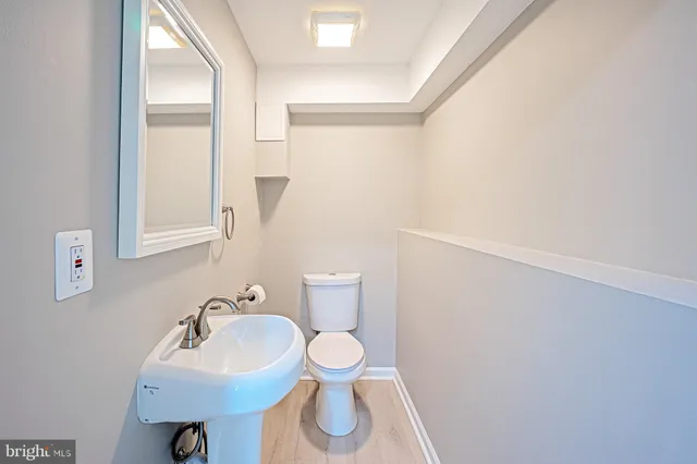 a bathroom with a sink toilet and a mirror