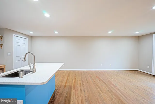 a kitchen with a sink and dishwasher with wooden floor