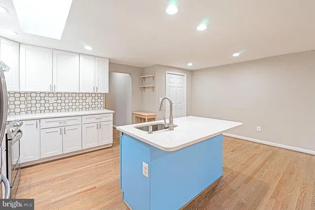 a kitchen with a sink cabinets and wooden floor