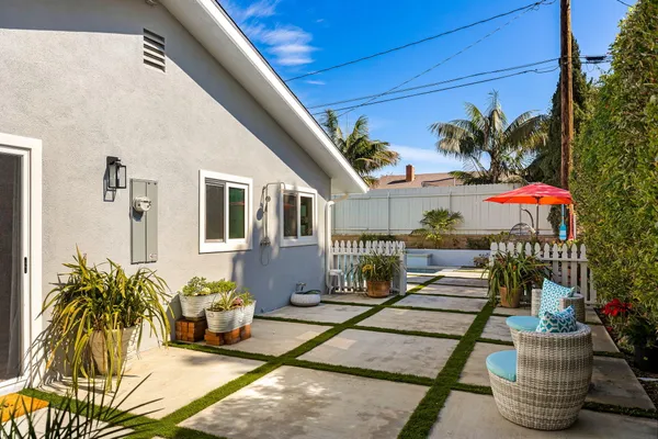 a view of a patio with table and chairs potted plants and palm tree