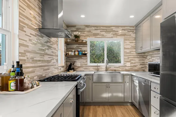 a kitchen with kitchen island granite countertop a sink cabinets and window