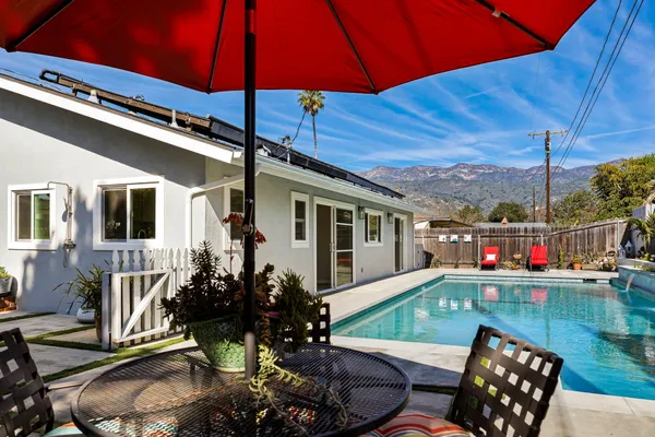 a view of a patio with table and chairs under an umbrella