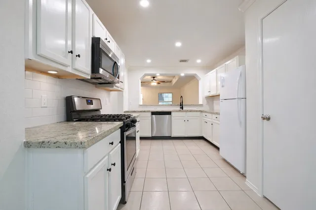 a kitchen with stainless steel appliances granite countertop a sink and cabinets