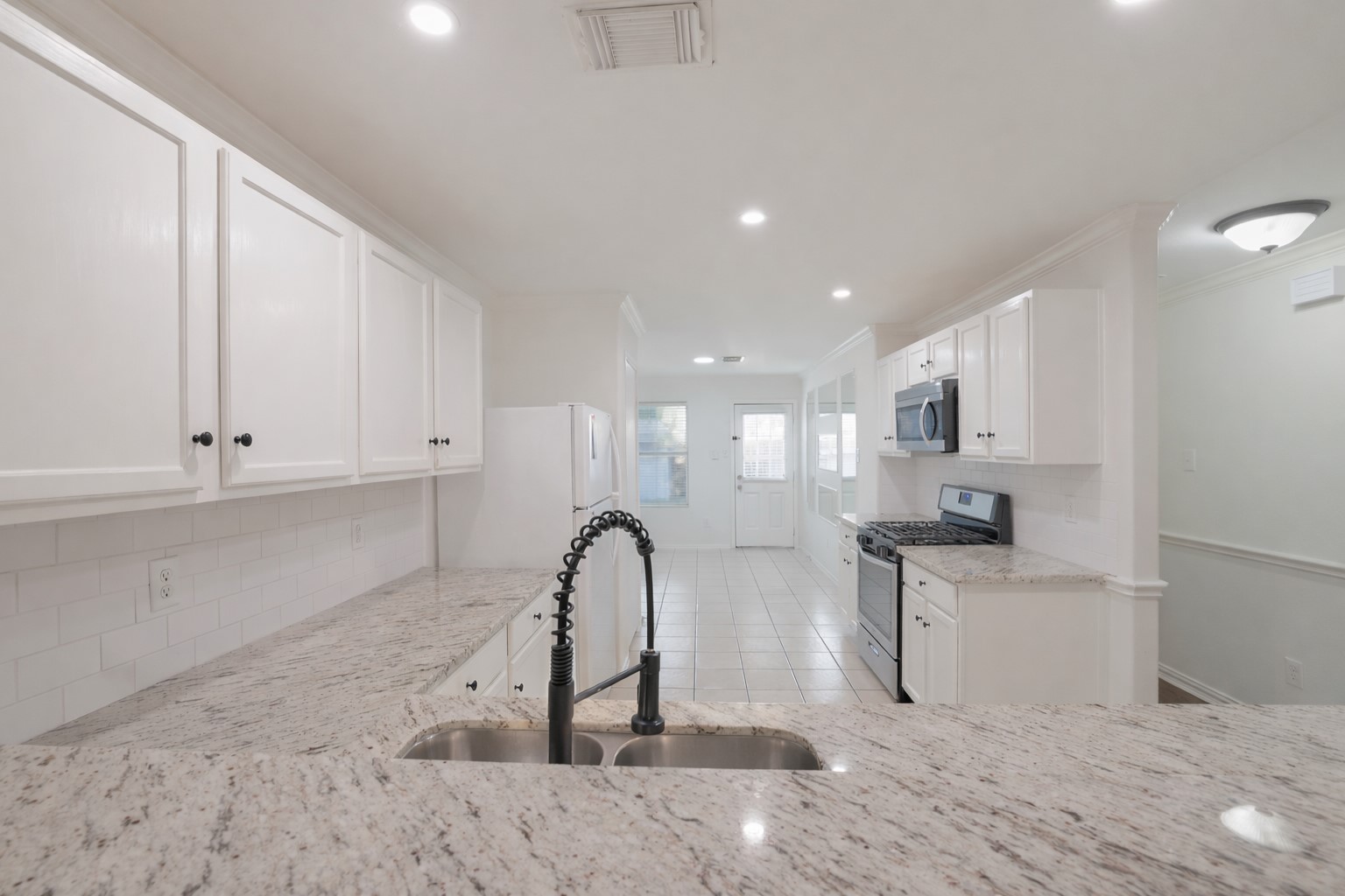 7907 Fire Thorn Lane Cypress, TX 77433 - Photo 9 of 17 a view of a kitchen with kitchen island a sink stainless steel appliances and cabinets