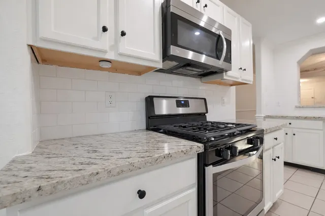 a kitchen with stainless steel appliances granite countertop a stove and a microwave