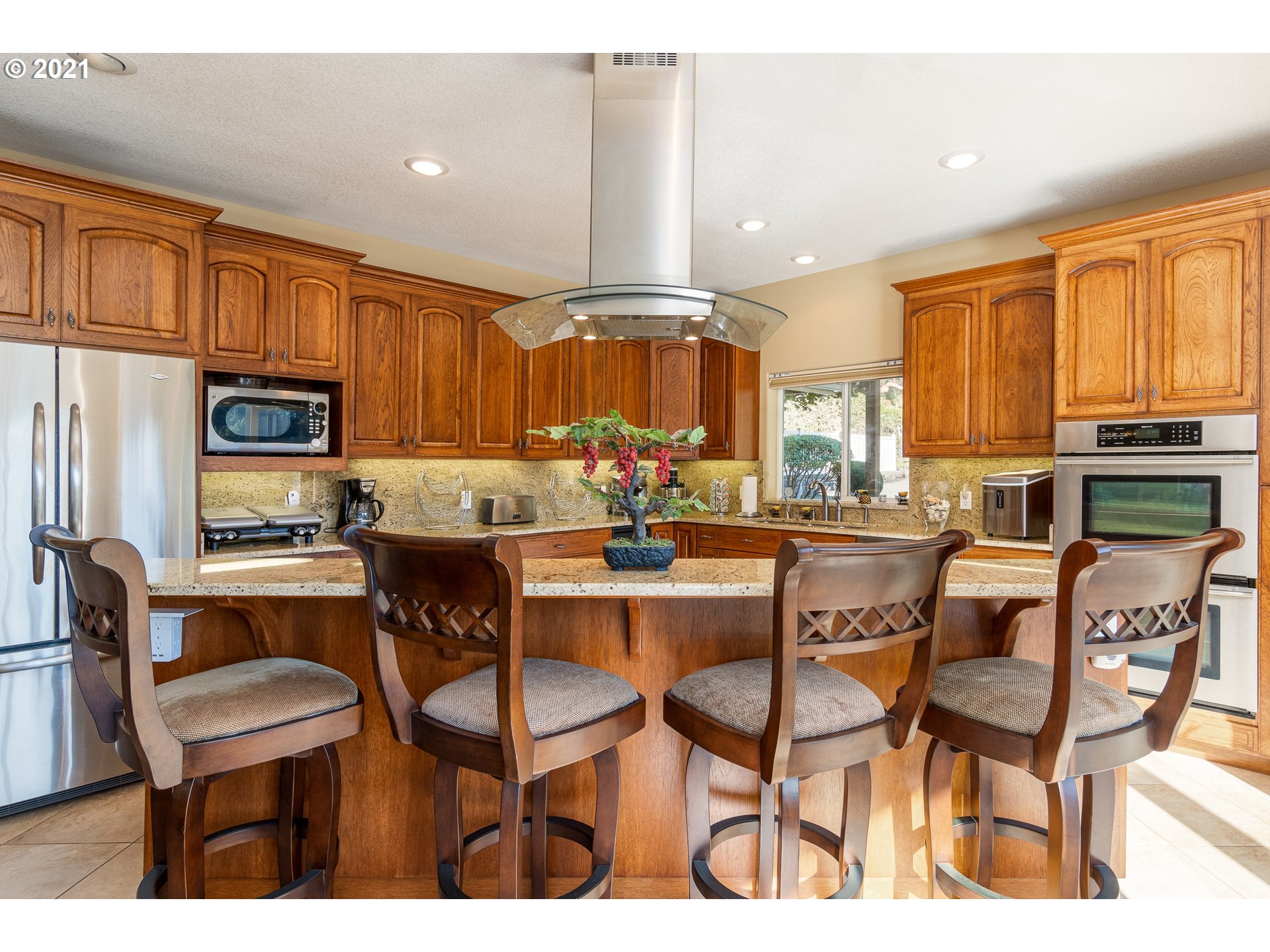 70946 Devore Arm Road Lakeside, OR 97449 - Photo 10 of 48 a kitchen with granite countertop a table chairs microwave and cabinets