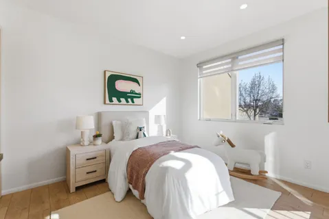 a bedroom with a bed and a painting on the wall