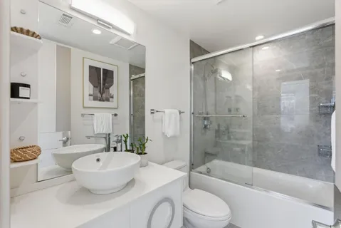 a bathroom with a granite countertop sink toilet and shower
