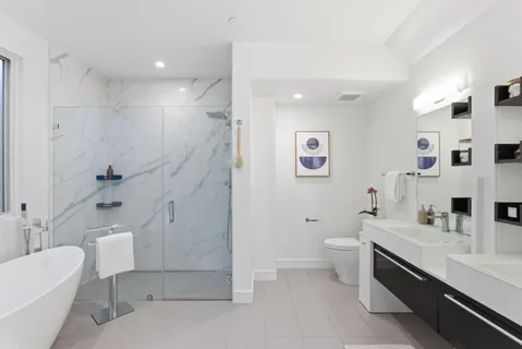 a bathroom with a double vanity sink toilet and shower