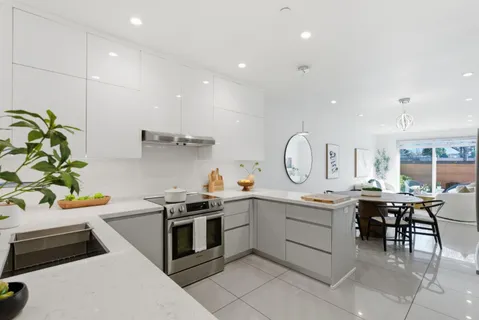 a kitchen with a sink white cabinets and stainless steel appliances