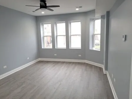 wooden floor in an empty room with a kitchen