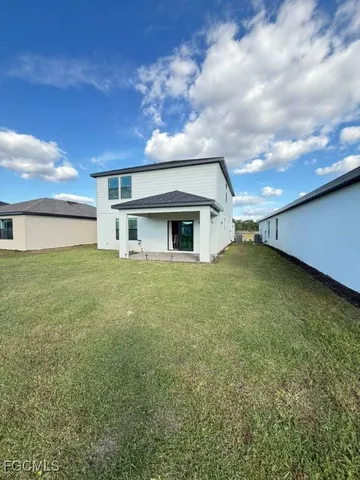 a big yard with table and chairs under an umbrella