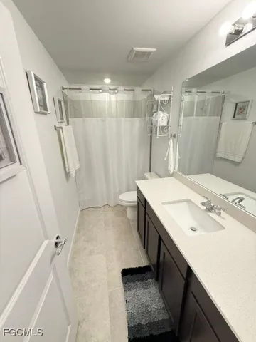 a bathroom with a sink a toilet a mirror and shower