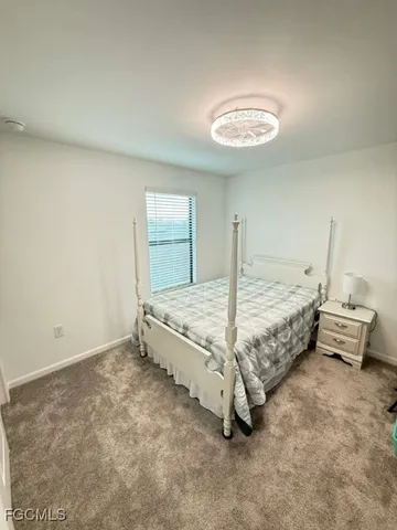 a bed sitting in a spacious bedroom next to a window