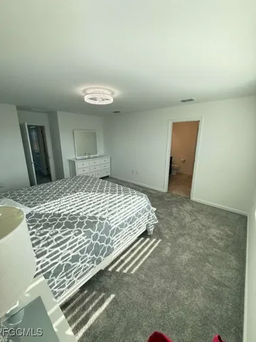 a spacious bedroom with a bed and a couch