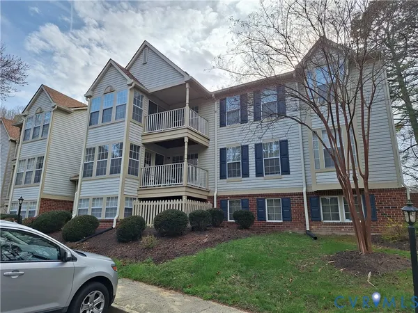 a front view of a house with a garden and trees
