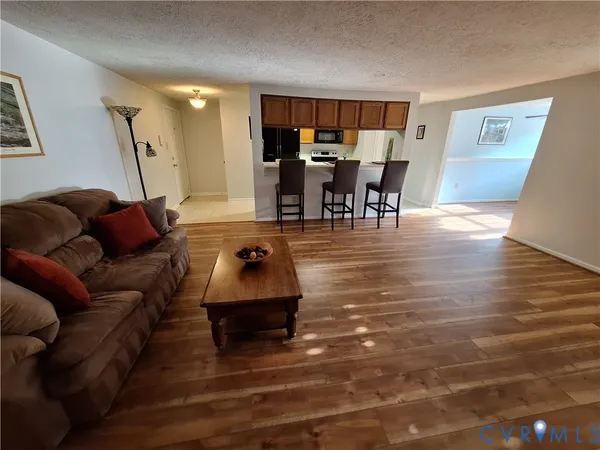 a living room with furniture and a wooden floor