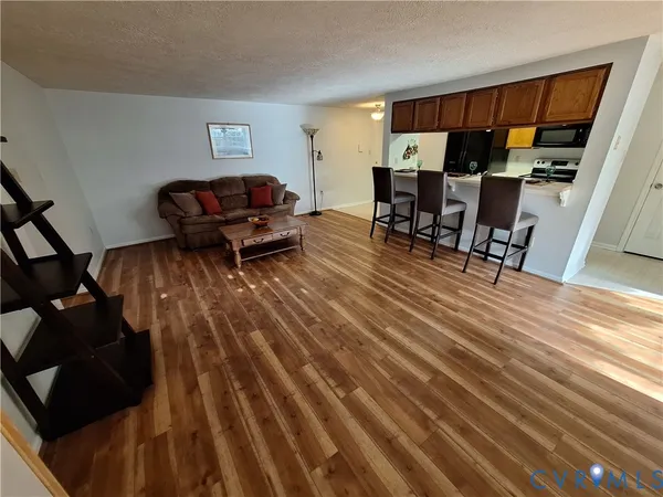 a living room with furniture and a wooden floor