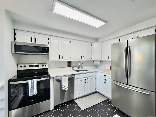 a kitchen with stainless steel appliances a refrigerator sink and cabinets