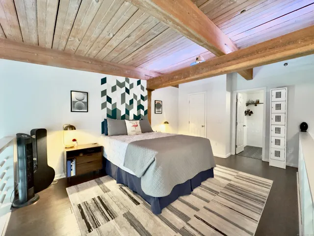 a spacious bedroom with a bed and a dresser