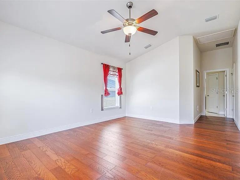 404 Rio Grande Court Poinciana, FL 34759 - Photo 11 of 21 an empty room with wooden floor and ceiling fan
