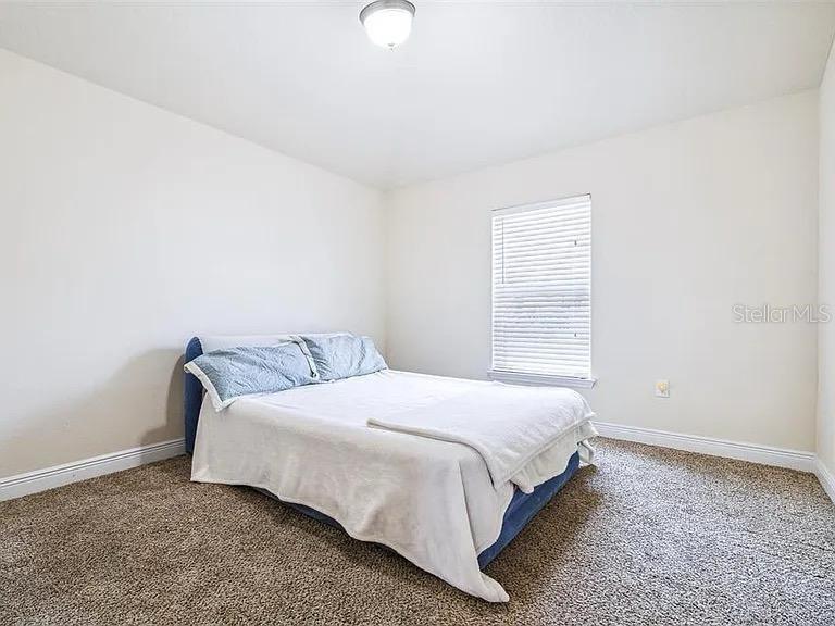 404 Rio Grande Court Poinciana, FL 34759 - Photo 16 of 21 a bedroom with a bed and a window
