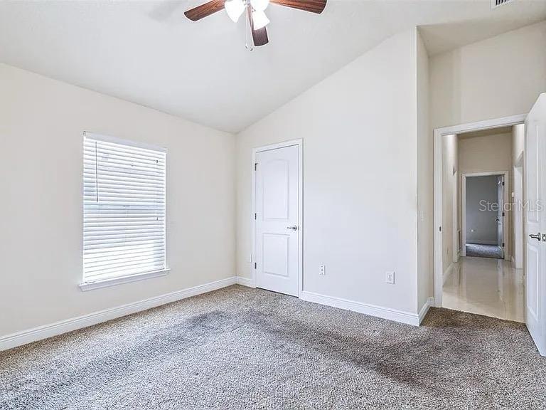 404 Rio Grande Court Poinciana, FL 34759 - Photo 17 of 21 an empty room with chandelier fan and windows