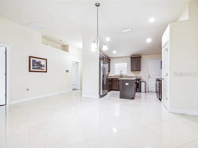 404 Rio Grande Court Poinciana, FL 34759 - Photo 4 of 21 a large white kitchen with kitchen island a sink stainless steel appliances and cabinets
