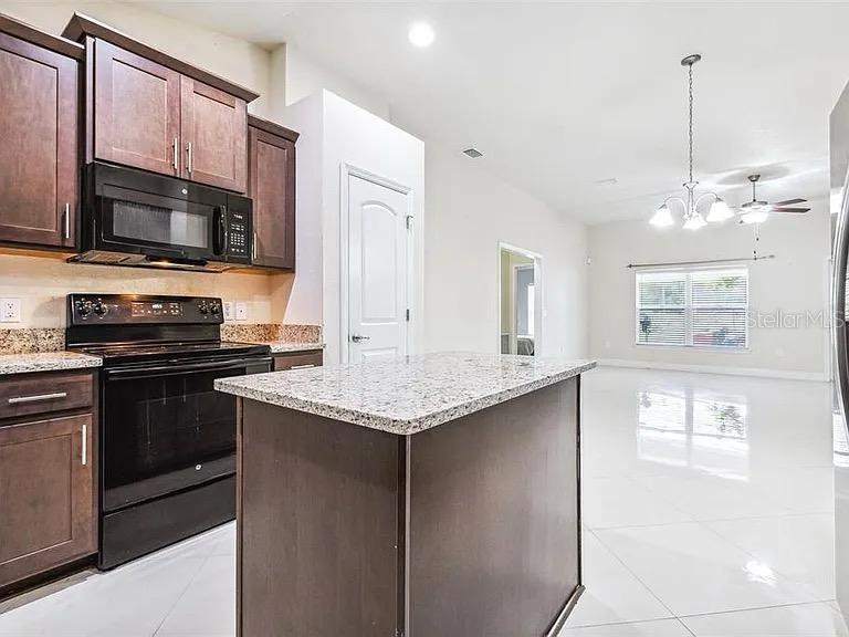 404 Rio Grande Court Poinciana, FL 34759 - Photo 9 of 21 a kitchen with stainless steel appliances granite countertop a sink and a microwave