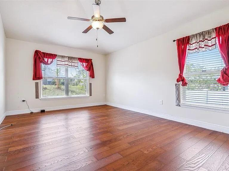 404 Rio Grande Court Poinciana, FL 34759 - Photo 10 of 21 an empty room with wooden floor chandelier fan and windows