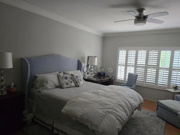 a bedroom with a bed a window and a chandelier