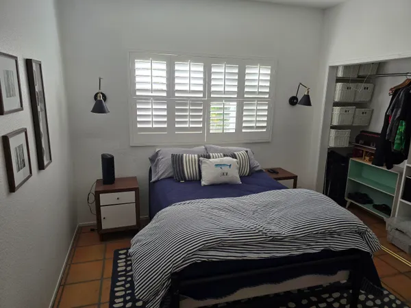 a bedroom with a bed wooden floor and a book shelf