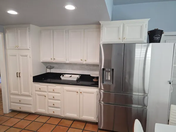 a kitchen with appliances cabinets and utility