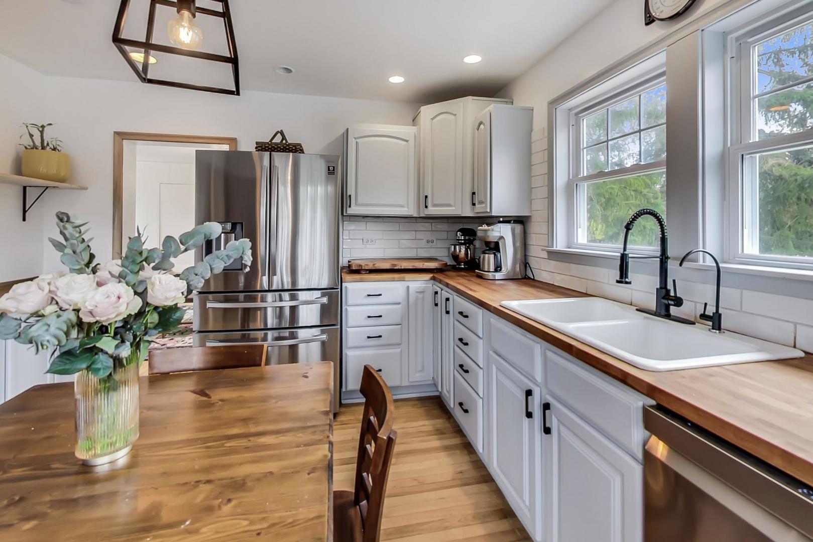 20792 Illinois Rte 59 Barrington, IL 60010 - Photo 13 of 35 a kitchen with stainless steel appliances granite countertop a sink a stove and a wooden floors