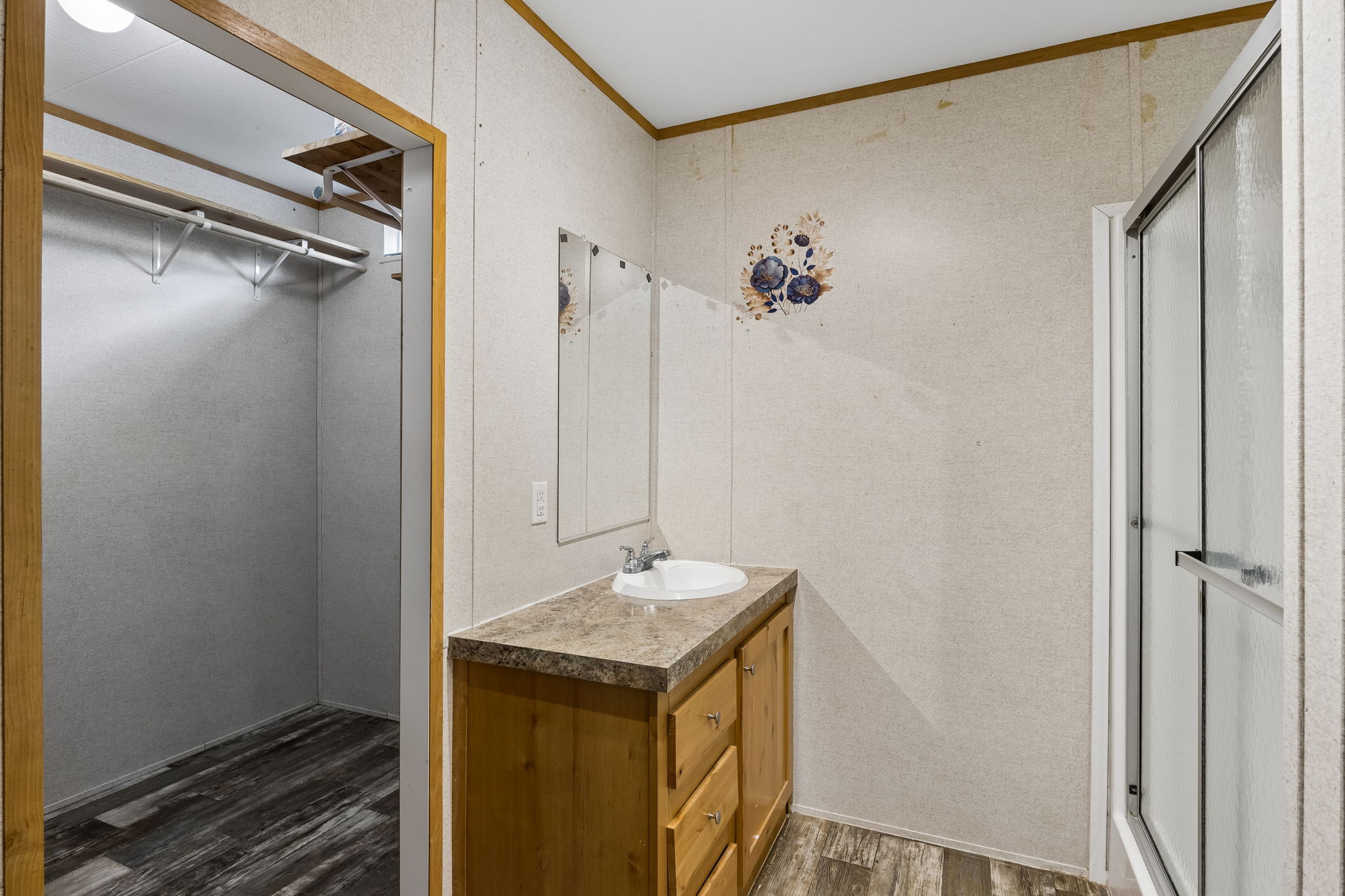 253 North County Line Road, Unit C Elgin, TX 78621 - Photo 16 of 39 Functional vanity and shower alongside a spacious walk-in closet with ample storage.