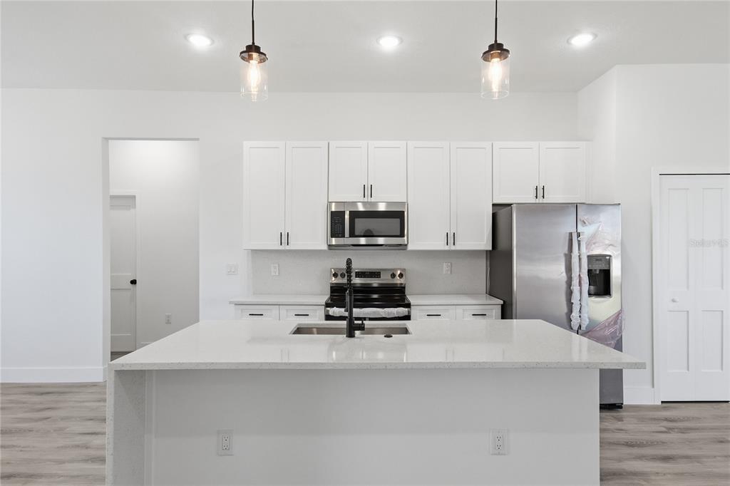 2600 Southwest 146th Pl Road Ocala, FL 34473 - Photo 39 of 40 a kitchen with kitchen island a white counter top space stainless steel appliances and cabinets