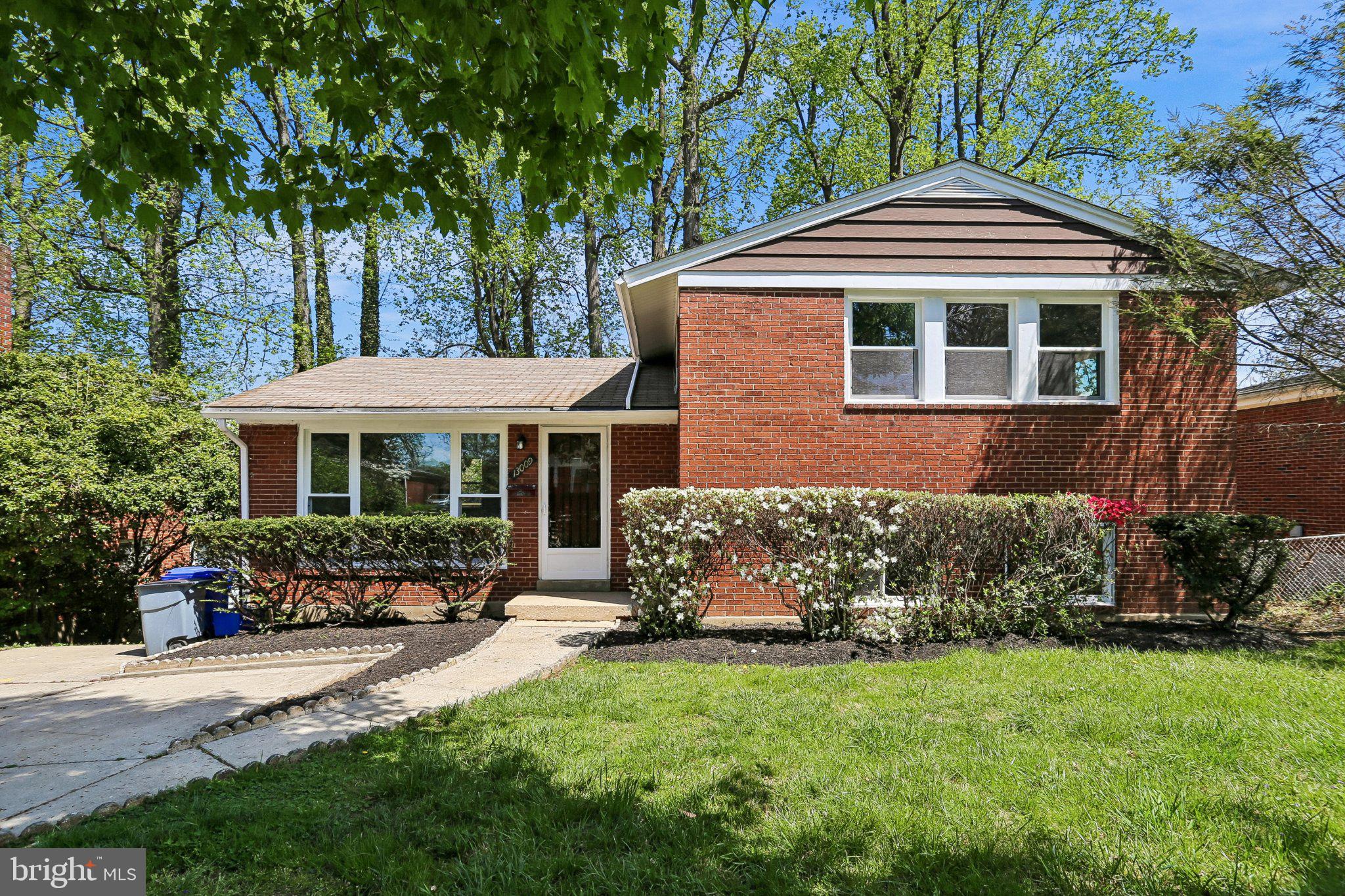 Charming brick home with lush greenery.