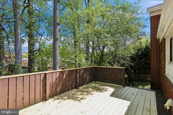 a view of wooden deck and a yard with wooden fence