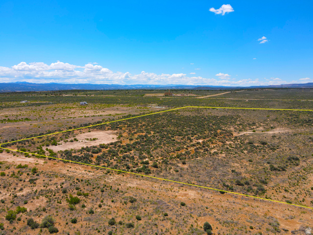 4500 South 22750th Duchesne, UT 84021 - Photo 7 of 34 Expansive undeveloped land parcel outlined in yellow, featuring varied desert vegetation and distant mountain ranges under a clear sky