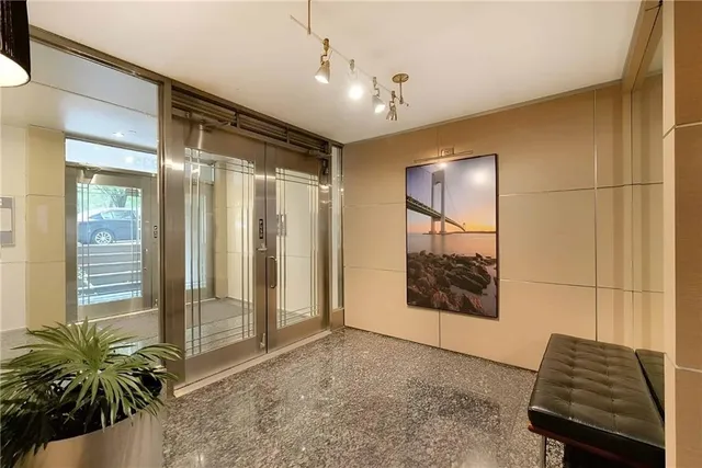 a view of a hallway with wooden floor and a potted plant