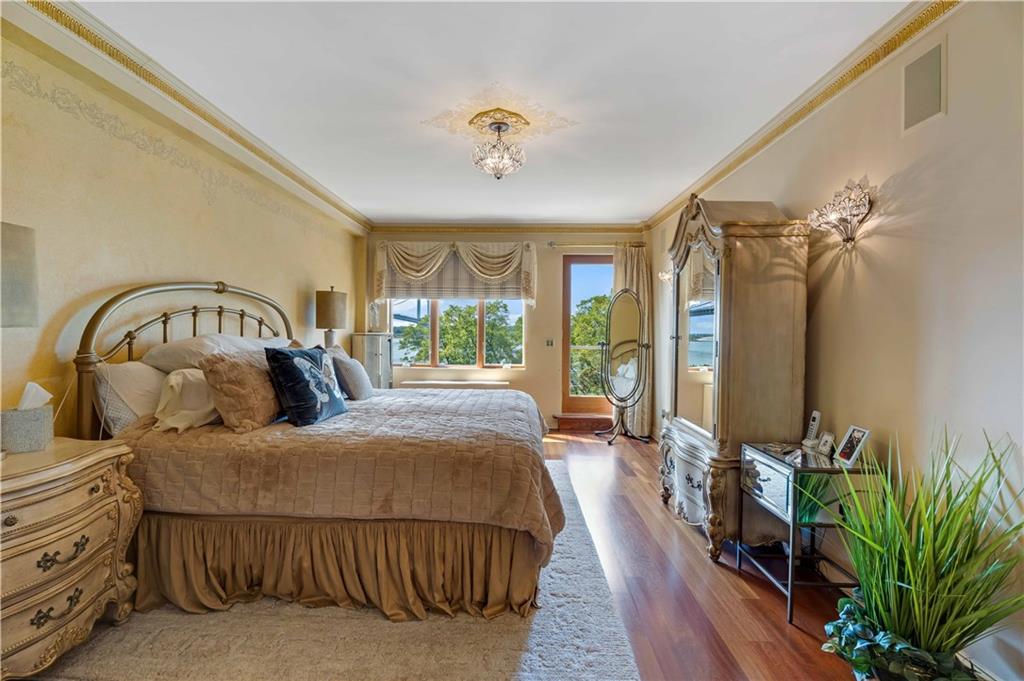 9935 Shore Road, Unit 6B Brooklyn, NY 11209 - Photo 6 of 9 a bedroom with a bed and a chandelier