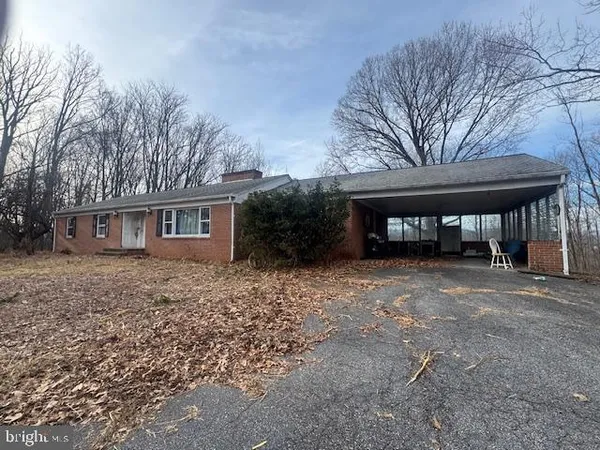 a front view of a house with a yard and trees
