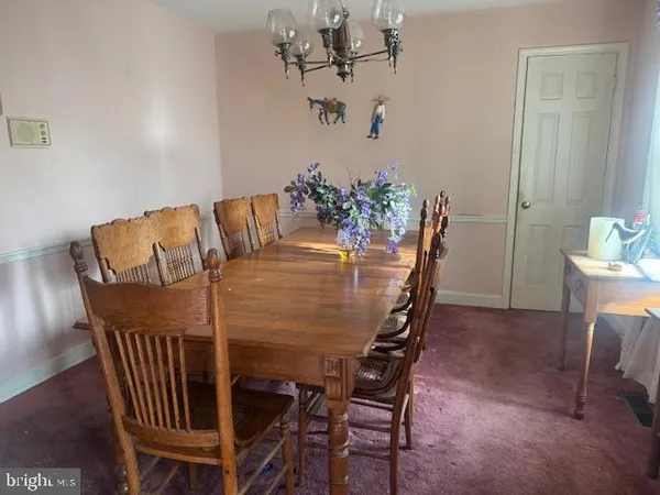 a view of a dining room with furniture and chandelier