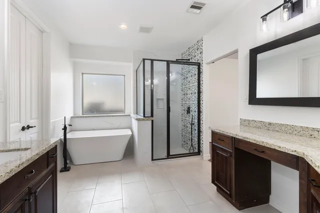 a bathroom with a granite countertop sink a mirror and a bathtub