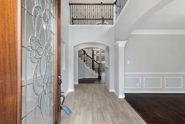 a view of a hallway with wooden floor and staircase