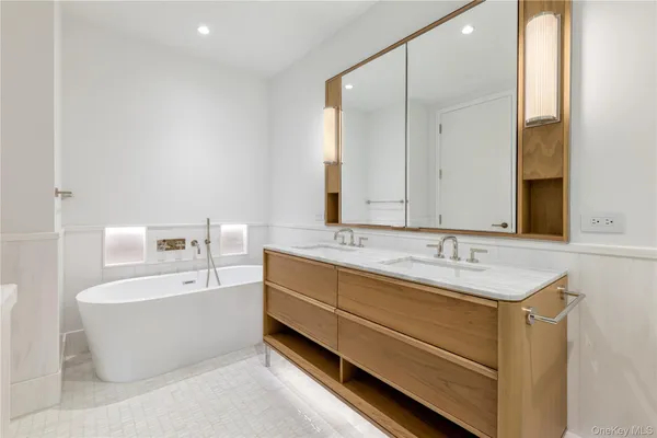 a bathroom with a tub a sink and mirror